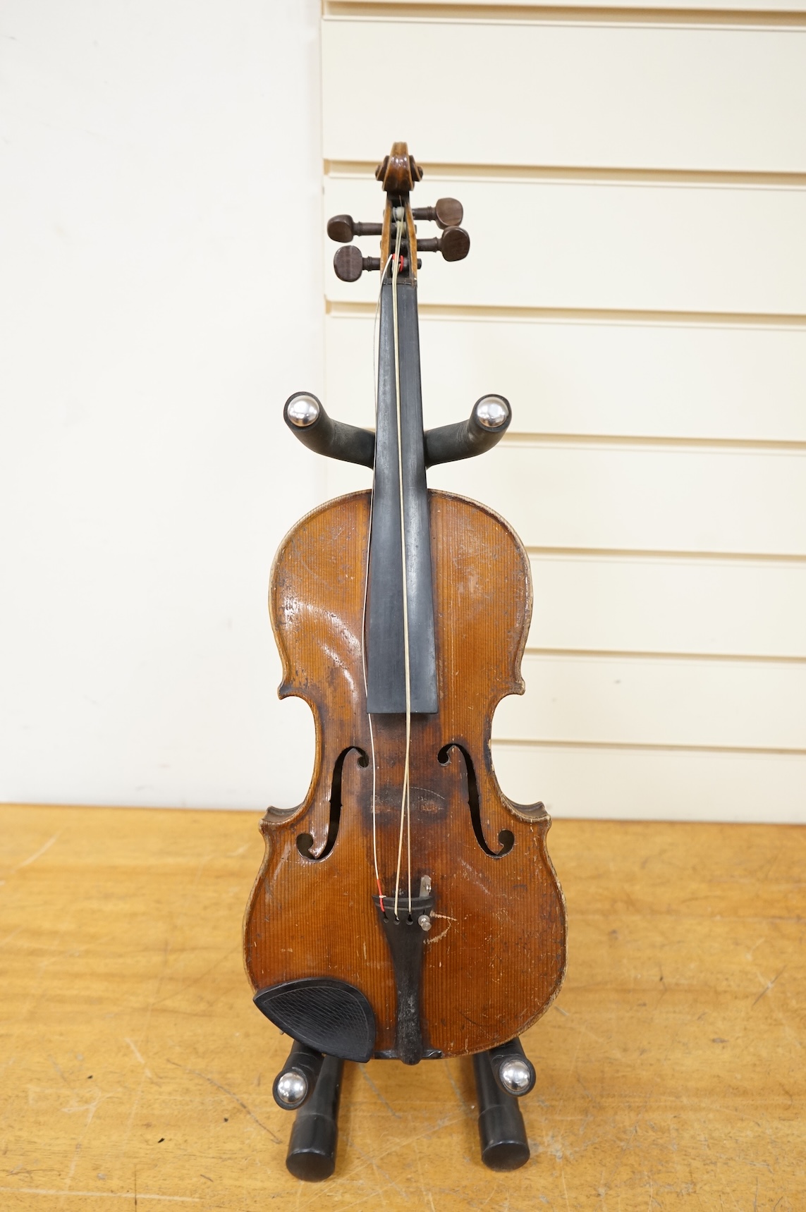 Five cased 20th century violins, including; a German violin, two Czech violins, a three-quarter size violin with a label for Bienfait, and a Romanian quarter size violin, all in cases or the remains of cases.